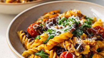 Bowl of vegan pasta with creamy sauce and fresh vegetables