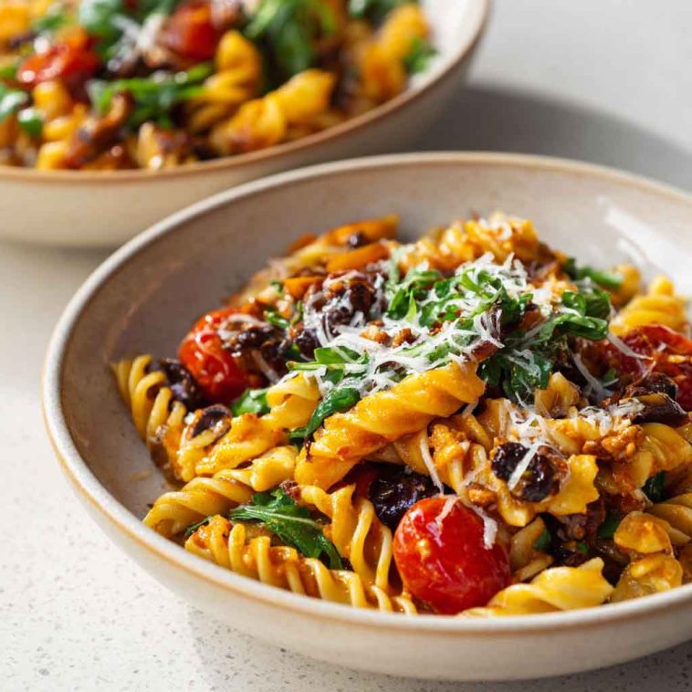 Bowl of vegan pasta with creamy sauce and fresh vegetables