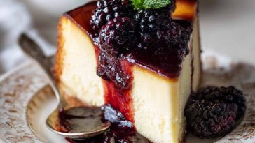 "A rich London Fog Basque cheesecake topped with blackberry sauce and garnished with fresh berries."