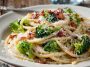 Creamy bucatini pasta tossed with melted cheese, crispy maple bacon, and tender broccoli florets served in a rustic bowl.