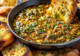 Delicious loaded bread dipping oil made with olive oil, garlic, herbs, and spices, served with crusty bread.