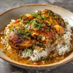 "A hearty plate of smothered chicken served over fluffy rice with rich gravy and fresh herbs."