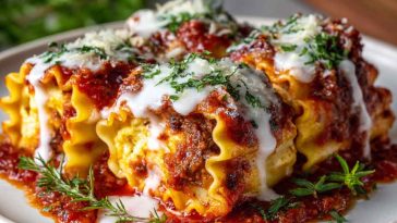 Lasagna rolls filled with ricotta, spinach, and marinara sauce, rolled up and baked with melted cheese on top.