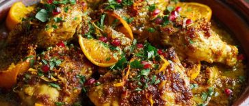 Traditional Moroccan chicken and orange tagine with tender chicken, citrus slices, olives, and aromatic spices served in a clay tagine pot.