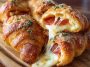 Golden croissant rolls stuffed with mozzarella and pepperoni, served warm on a platter