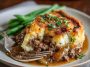 Amish hamburger steak bake casserole with melted cheese and golden potatoes