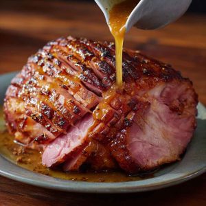 Honey mustard glazed ham sliced and served on a holiday platter