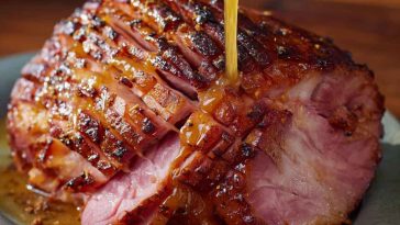 Honey mustard glazed ham sliced and served on a holiday platter