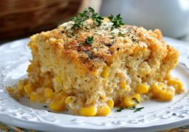 Slow cooker cream cheese corn casserole with golden, creamy corn filling served in a rustic dish, garnished with fresh herbs.