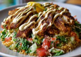 Chicken shawarma crispy rice salad topped with spiced chicken, fresh vegetables, crispy rice, and drizzled with lemon-tahini dressing.