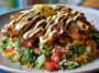 Chicken shawarma crispy rice salad topped with spiced chicken, fresh vegetables, crispy rice, and drizzled with lemon-tahini dressing.