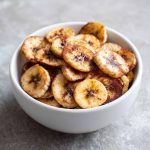 "A basket of crispy air fryer cinnamon banana chips served as a healthy snack."