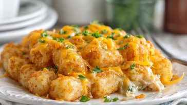 "Golden cheddar ranch chicken tater tot bake fresh from the oven, topped with melted cheese and crispy tater tots."