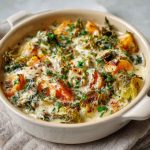 Creamy winter vegetable casserole baked with broccoli, cauliflower, carrots, and a cheesy sauce, served hot in a rustic dish.