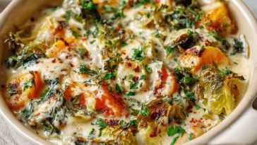 Creamy winter vegetable casserole baked with broccoli, cauliflower, carrots, and a cheesy sauce, served hot in a rustic dish.