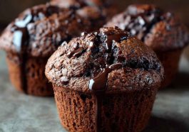Double chocolate muffins with rich cocoa flavor, gooey melted chocolate chips, and a moist, fluffy texture served warm.