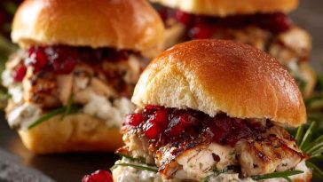 Cranberry turkey sliders made with tender turkey, melted cheese, cranberry sauce, and soft slider buns baked golden brown.
