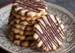 Piped chocolate butter cookies with delicate swirls, rich cocoa flavor, and a crisp buttery texture baked golden brown.