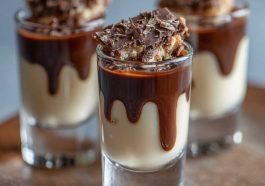 Creamy chocolate pudding shots infused with Kahlua and Bailey’s Irish Cream, topped with whipped cream and chocolate shavings in festive shot glasses.