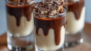 Creamy chocolate pudding shots infused with Kahlua and Bailey’s Irish Cream, topped with whipped cream and chocolate shavings in festive shot glasses.