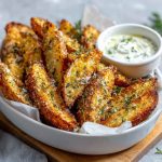Crispy garlic parmesan potato wedges baked golden brown, sprinkled with fresh parsley and served with dipping sauce.