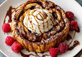 "Golden cinnamon roll French toast topped with cream cheese glaze and dusted with cinnamon sugar."