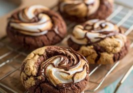 Chocolate marshmallow swirl cookies with gooey marshmallow ribbons baked into rich chocolate cookie dough, served on a rustic tray.