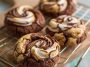 Chocolate marshmallow swirl cookies with gooey marshmallow ribbons baked into rich chocolate cookie dough, served on a rustic tray.