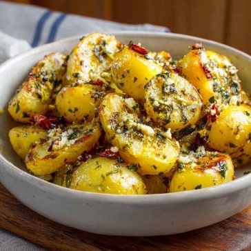 Greek-style lemon potatoes roasted with garlic, oregano, and olive oil until golden and crispy, served with fresh herbs.