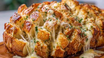 Cheesy pull-apart garlic bread baked golden brown, stuffed with melted mozzarella, garlic butter, and fresh herbs.