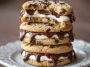 Chocolate chip cheesecake cookies with gooey chocolate chips, creamy cheesecake filling, and golden cookie edges served on a plate.