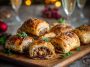Golden Christmas sausage rolls on a festive platter with herbs