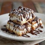 Classic cannoli squares with creamy ricotta filling, chocolate chips, and powdered sugar dusted on top.