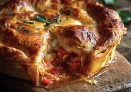 Golden pizza pot pie with melted cheese and tomato sauce inside