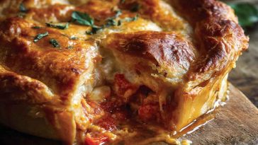Golden pizza pot pie with melted cheese and tomato sauce inside