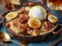 Warm bananas foster cobbler baked with caramelized bananas, brown sugar, and rum sauce topped with golden biscuit crust.