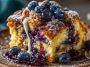 Blueberry French toast casserole baked golden with fresh blueberries and syrup drizzle
