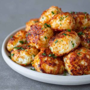 Two ingredient cottage cheese tots baked golden brown, crispy on the outside and soft inside, served as a healthy snack.