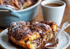 Chocolate croissant breakfast bake made with flaky croissants layered with rich chocolate and custard, baked golden brown in a casserole dish.