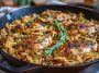 One pan Marry Me chicken orzo with tender chicken, creamy sauce, sun-dried tomatoes, and fresh herbs served in a skillet.