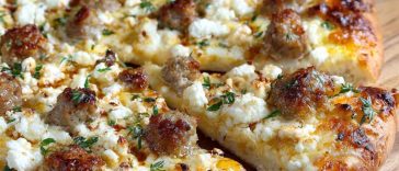 Hot sausage feta honey pizza topped with spicy sausage, creamy feta, and a drizzle of golden honey on a crispy crust.