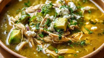 Bowl of creamy chicken poblano soup with tender chicken, roasted poblano peppers, corn, and fresh cilantro garnish.