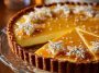 Eggnog crème tart topped with golden caramel shards, creamy custard filling, and a buttery tart crust served on a holiday table.