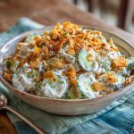 Fresh cucumber ranch crack salad with crisp cucumbers, creamy ranch dressing, shredded cheese, and crunchy bacon bits served in a bowl.
