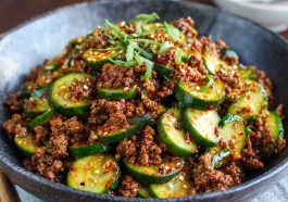 Spicy Korean ground beef served with fresh cucumber salad, garnished with sesame seeds and scallions.