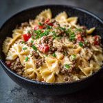 Bowtie pasta tossed in creamy Cajun Alfredo sauce with cream cheese, spiced ground beef, and fresh herbs.