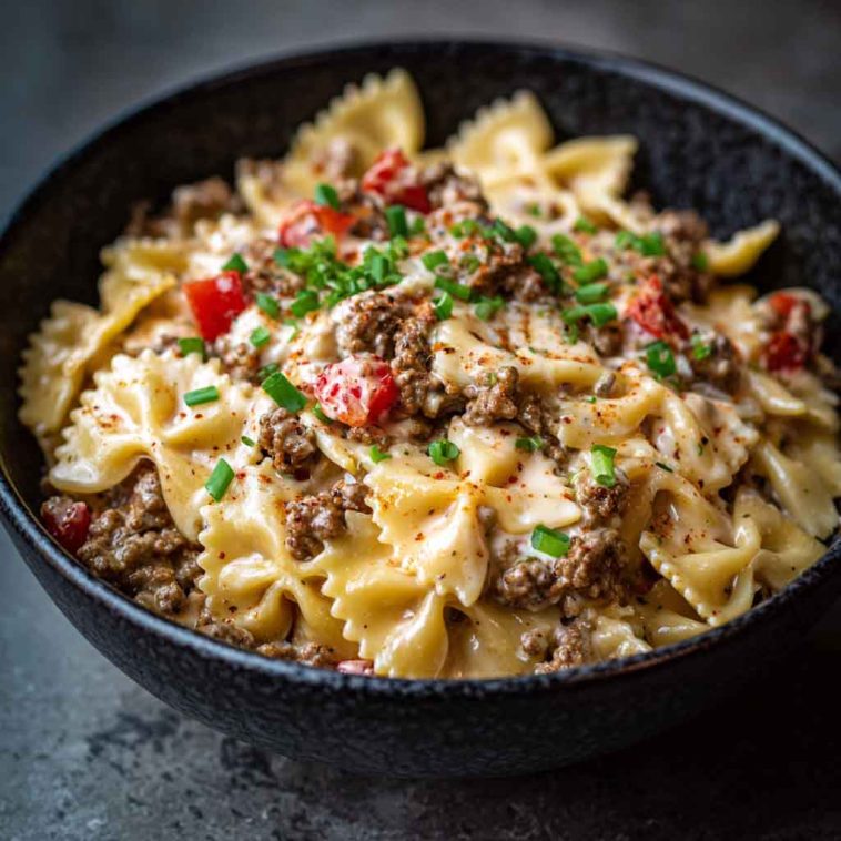 Bowtie pasta tossed in creamy Cajun Alfredo sauce with cream cheese, spiced ground beef, and fresh herbs.