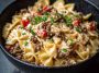Bowtie pasta tossed in creamy Cajun Alfredo sauce with cream cheese, spiced ground beef, and fresh herbs.