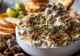 “Golden, cheesy stuffed mushroom dip served in a skillet, topped with herbs and bubbling Parmesan.”