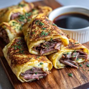 “Golden baked French dip tortilla roll ups filled with roast beef, melted cheese, and served with au jus dipping sauce.”